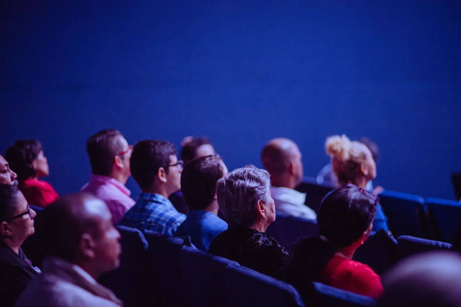 Delegates at a corporate convention following a presentation from the auditorium.