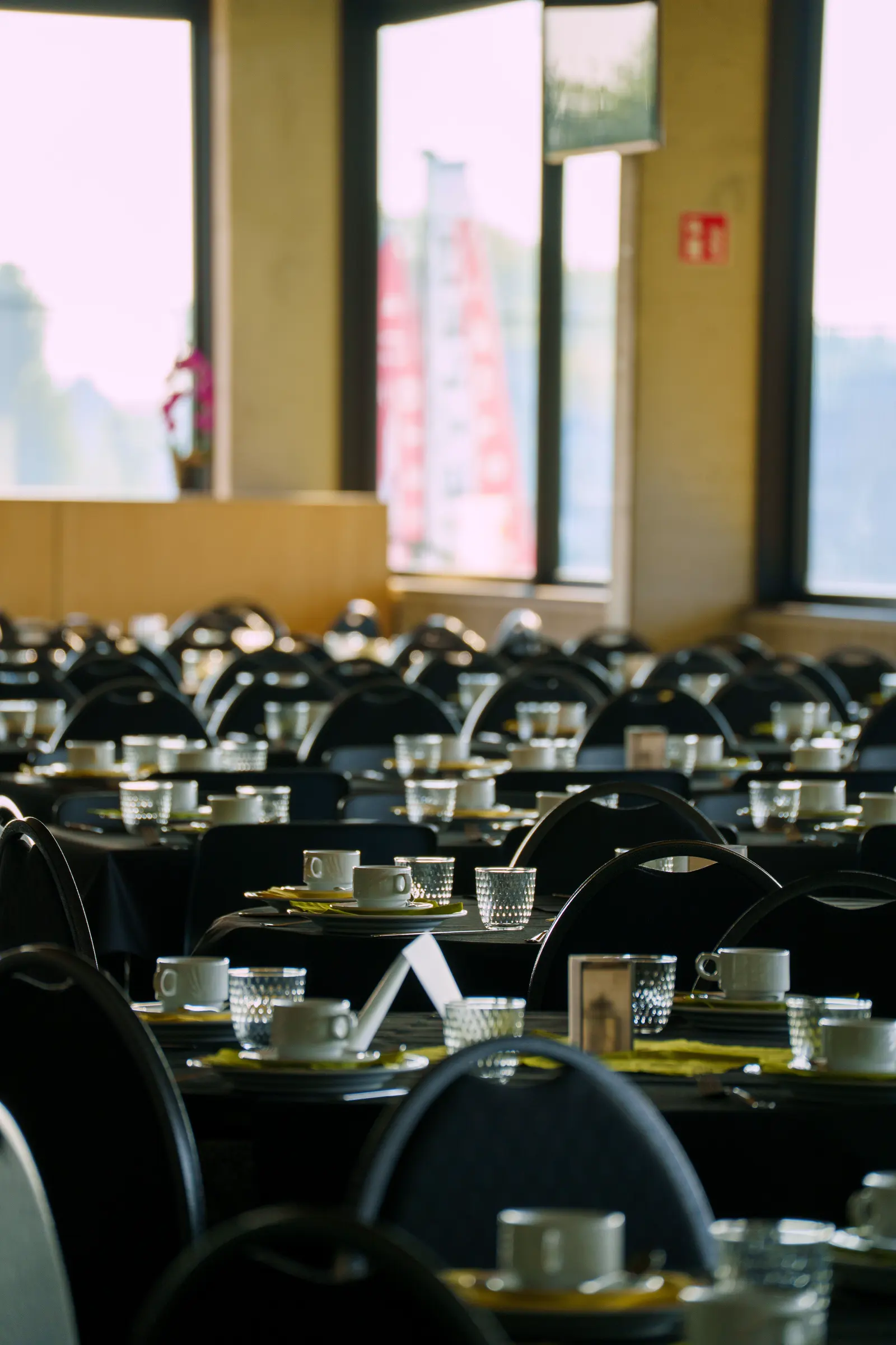 Comedor institucional con las mesas montadas y servidas, visto desde el fondo del salón.