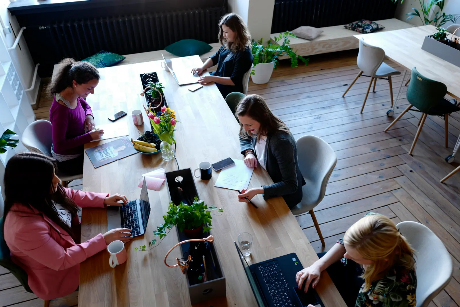Equipo de trabajo reunido alrededor de una mesa de oficina durante una jornada larga.