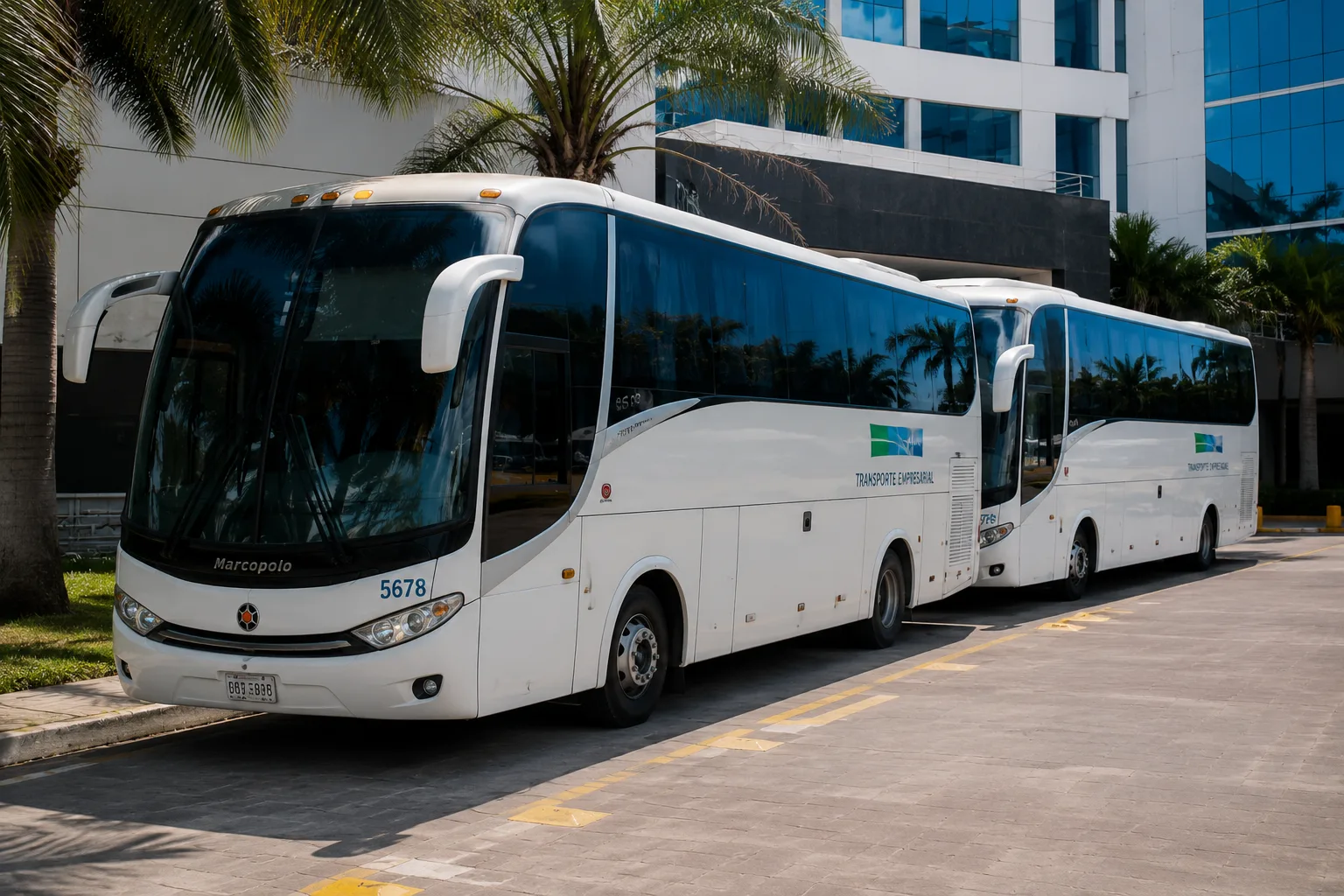 Dos buses de transporte empresarial estacionados frente a la sede de una empresa en Cartagena.